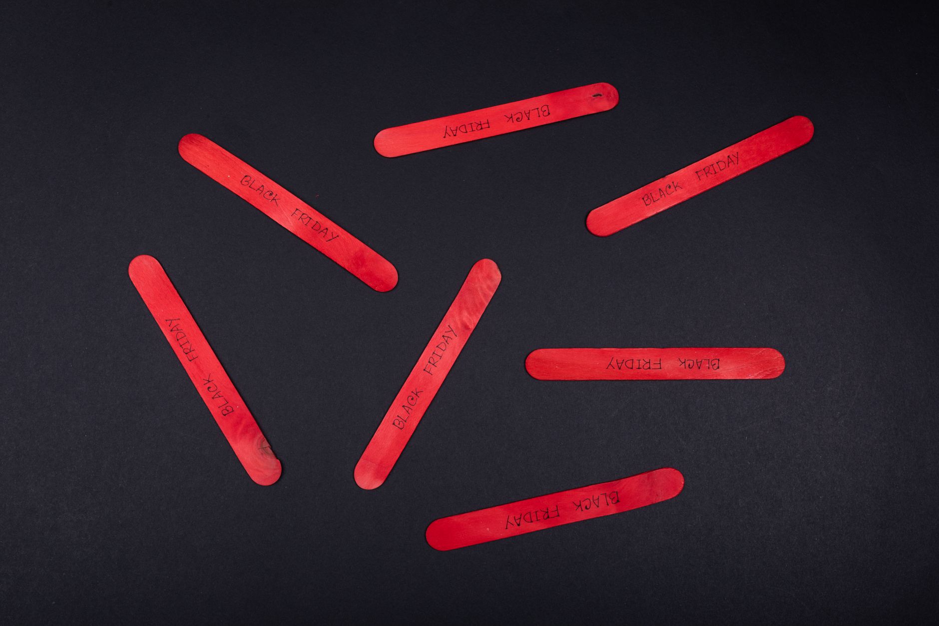 red popsicle sticks on black table