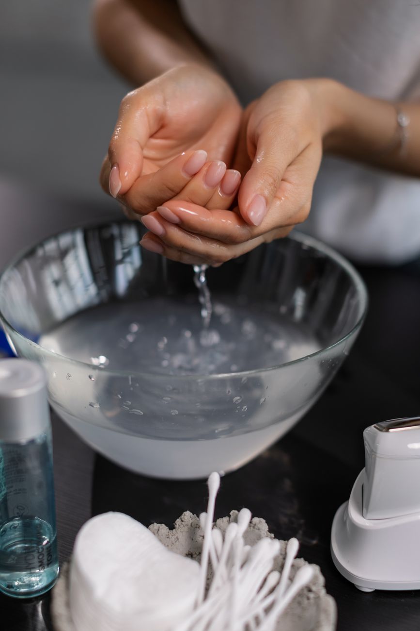 a close up shot of a woman taking water from a bowl with her hands