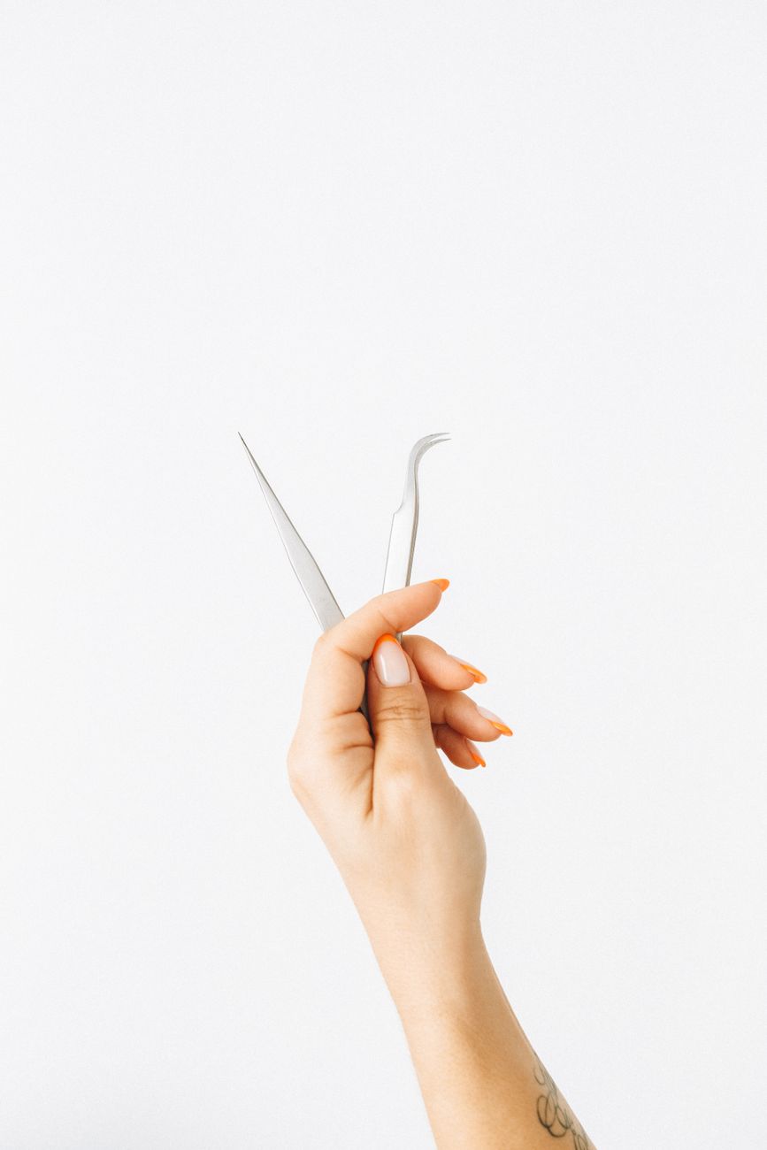 a person holding a stainless tweezers